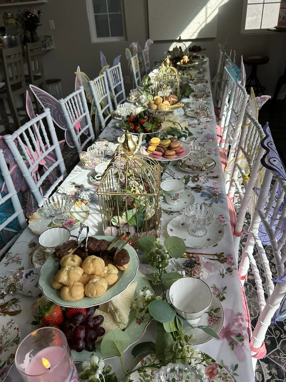 Sunlit tea table with macarons, china, flowers, and pink details